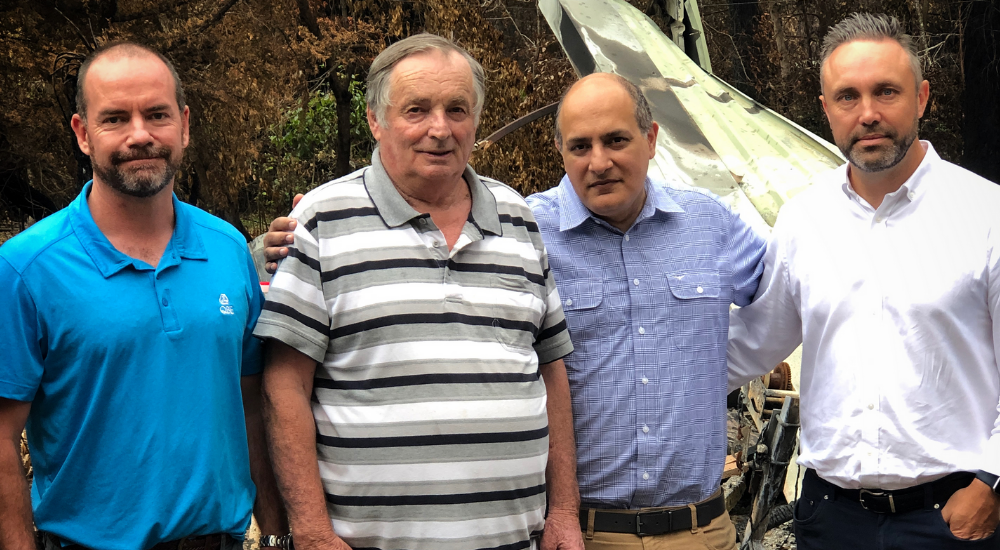 QBE AUSPAC CEO Vivek Bhatia and other members of the QBE team meet with a bushfire-affected customer at the scene of his destroyed property